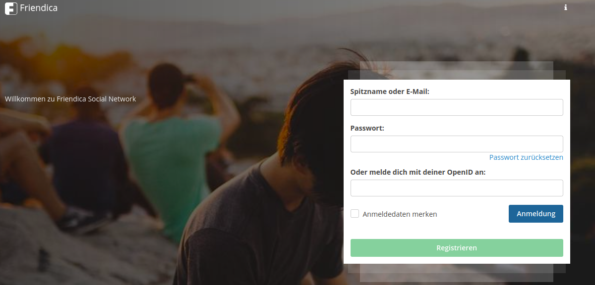 Das Bild zeigt die Anmeldeseite von Friendica, einem sozialen Netzwerk. Im Vordergrund befindet sich ein Anmeldeformular mit Feldern für den Spitznamen oder die E-Mail-Adresse und das Passwort. Es gibt auch eine Option, um das Passwort zurückzusetzen, sowie ein Feld zur Anmeldung mit einer OpenID. Zusätzlich gibt es eine Checkbox, um Anmeldedaten zu speichern, und einen Button zur Anmeldung. Unter dem Anmeldeformular befindet sich ein grüner Button zur Registrierung. Im Hintergrund ist ein unscharfes Bild von Menschen in einer Stadtlandschaft zu sehen. Oben links ist das Friendica-Logo mit dem Text "Willkommen zu Friendica Social Network" zu erkennen.